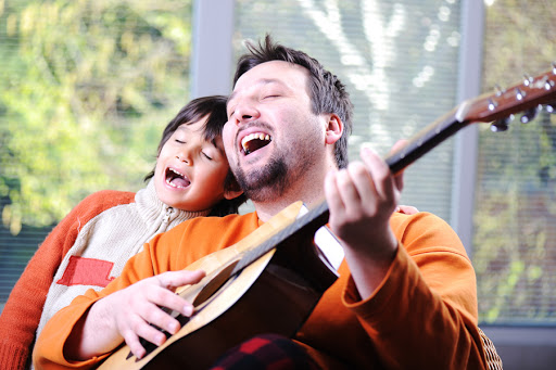 Father and son playing guitar at home &#8211; es