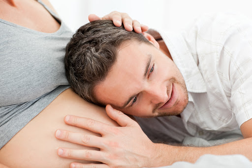 Husband listening to his wife&#8217;s belly &#8211; es