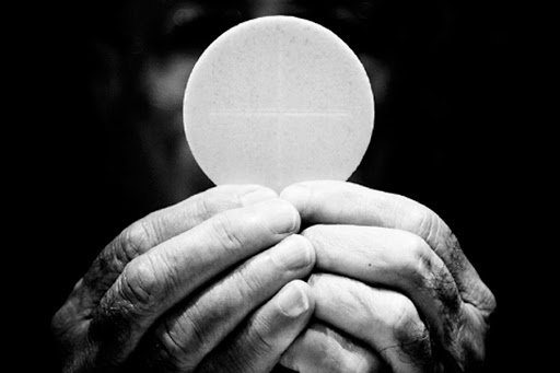 A priest holds eucharist &#8211; es