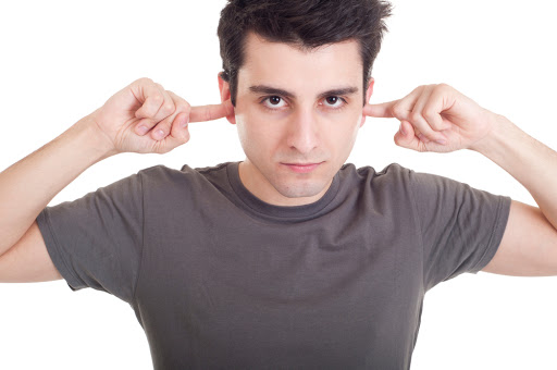 Man portrait with fingers in ear not listening expression &#8211; es