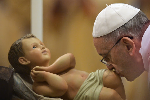 Pope Francis kisses the unveiled baby Jesus during a Christmas Eve mass at St Peter&#8217;s Basilica &#8211; es