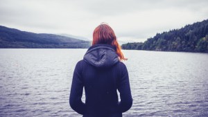 Woman admiring stillness of the lake – es