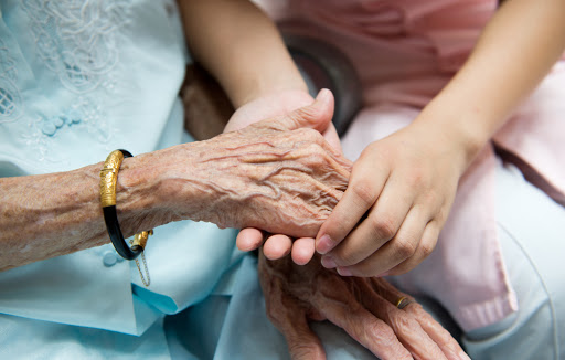 Young girl&#8217;s hand touches and holds an old woman&#8217;s wrinkled &#8211; es