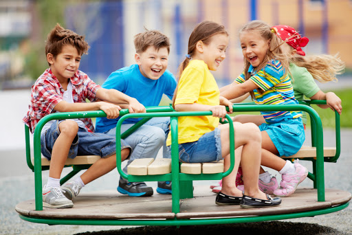 Image of joyful friends having fun on carousel outdoors &#8211; es