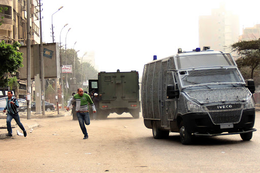 EGYPT, Cairo : Egyptian protestors run for covers near police vehicles &#8211; es