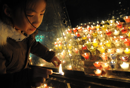 A South Korean girl lights candles at Myeongdong Catholic Cathedral in Seoul &#8211; es