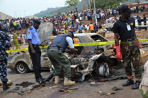 NIGERIA, Abuja : Nigerian security personnel inspect the site of a blast at Nyanya bus station &#8211; es