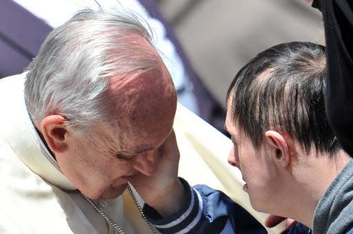 A down&#8217;s syndrome boy caresses Pope Francis &#8211; es
