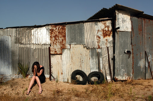 Traumatized young women sit outside an old warehouse &#8211; es