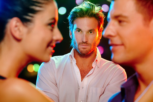 Handsome jealous man looking at flirting couple on dance floor – es