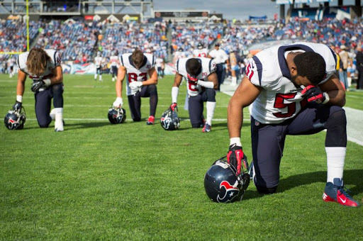Jugadores de football americano rezando