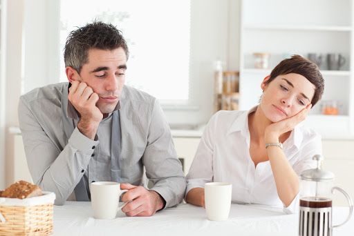 Exhausted couple drinking coffee in a kitchen &#8211; es