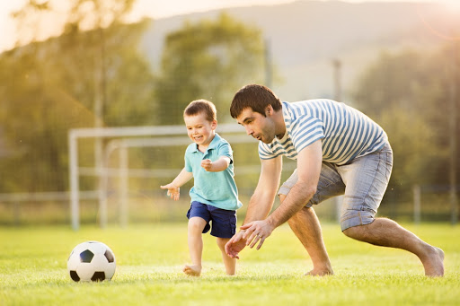 Young father with his little son playing football on football pitch &#8211; es