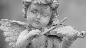 little angel playing violin – detail of cemetery decor, Italy – es
