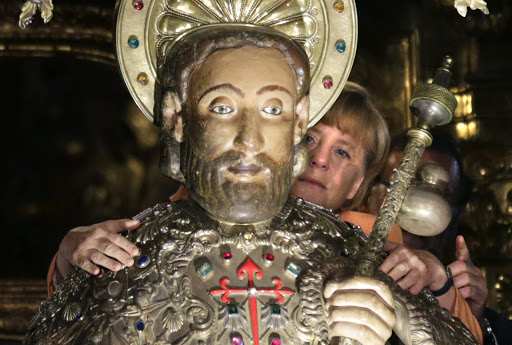 SPAIN, Santiago de Compostela : German Chancellor Angela Merkel embraces the statue of Saint James during a visit with Spanish Prime Minister Mariano Rajoy at the cathedral of Santiago de Compostela &#8211; es