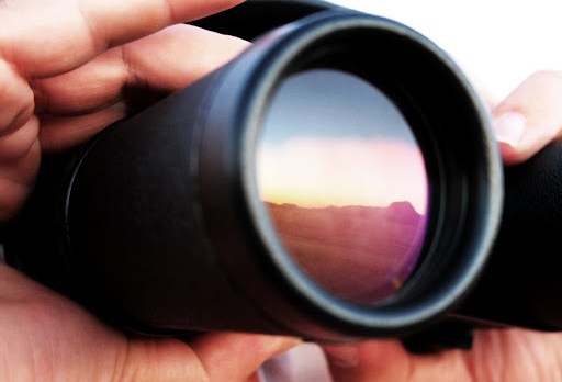 Hombre mirando a través de un binocular