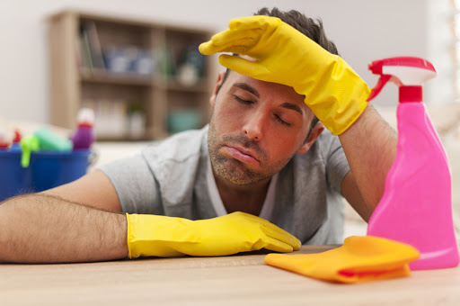Tired man with cleaning equipment – es