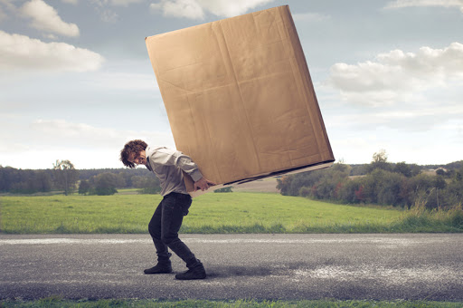 Man carrying on his shoulders a large box &#8211; es