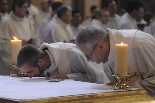 A priest is kissing the altar – es