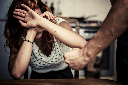 Woman covering her face in fear of domestic violence &#8211; es