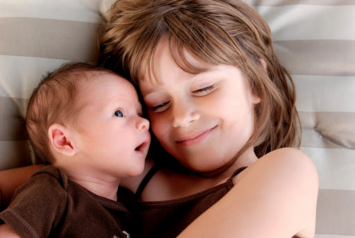 A sister giving her baby brother some affection – es