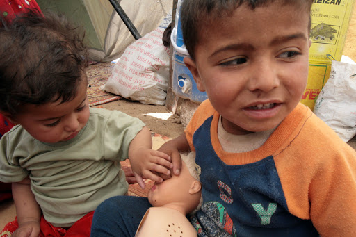 Iraqi children play at the entrance of their family&#8217;s tent at a camp for refugees &#8211; es