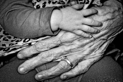 mano de anciana y mano de bebé
