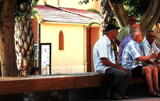 Hombres españoles mayores discutiendo en una plaza