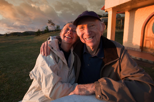 Loving elderly couple smiling at table in mountains &#8211; es