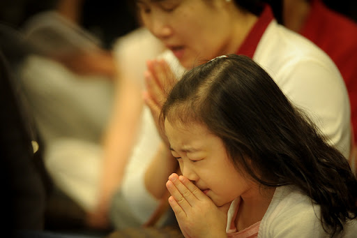 niña china y su madre rezando
