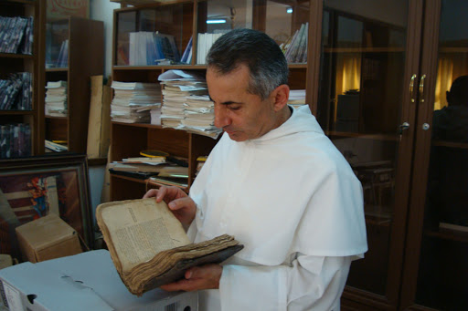 Father Najeeb Michaeel examines a manuscript &#8211; es