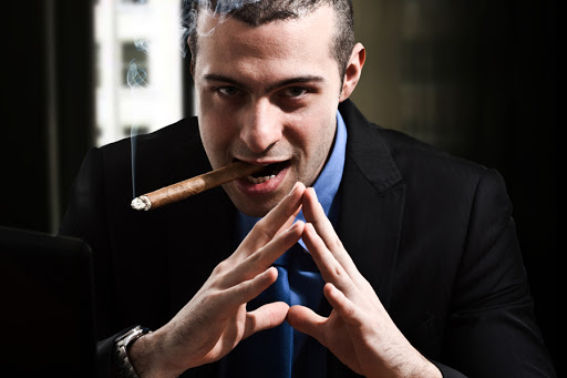 Shady man smoking a cigar in his office &#8211; es
