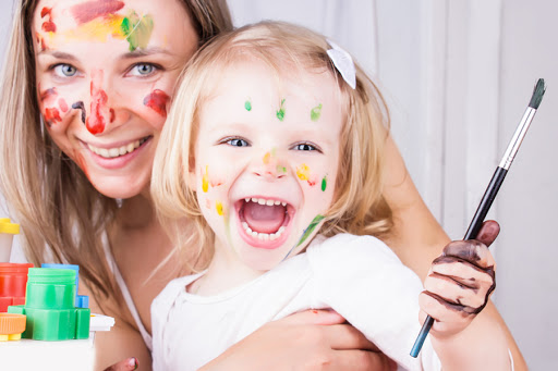 Happy mother and daughter with paint on faces &#8211; es