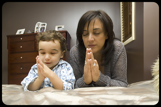 Young mother praying with child © Tony Bowler / Shutterstock &#8211; es
