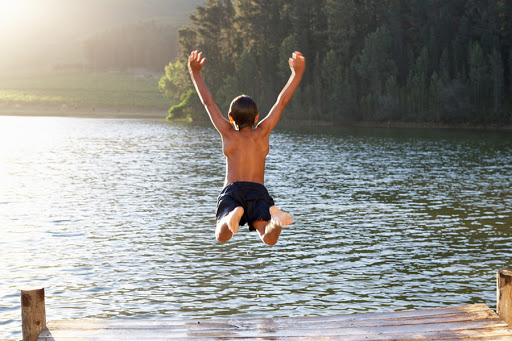 Young boy jumping into lake © Monkey Business Images / Shutterstock &#8211; es