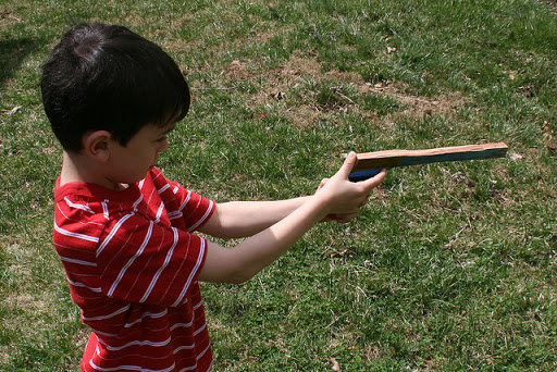 niño jugando con una pistola de madera