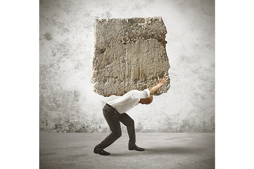 Concept of stress of a businessman with a big rock © Alphaspirit / Shutterstock &#8211; es