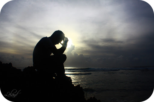 Man praying at oceanside &#8211; es