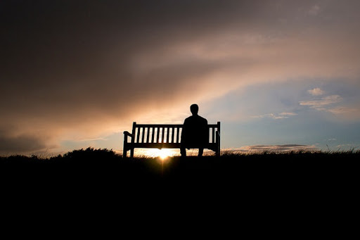 hombre solitario sentado en un banco