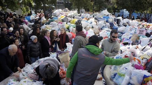 Volunteers help pass out free items to the poor in Athens