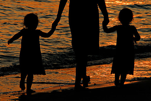 padre e hijos caminando a la orilla del mar