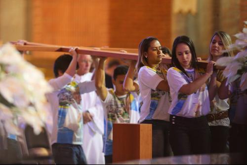 Jóvenes portan la Cruz de la JMJ durante una celebración Eucarística en la Basílcia de Aparecida en Brasil