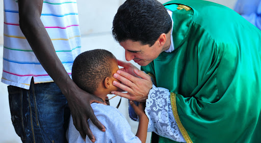sacerdote con niño