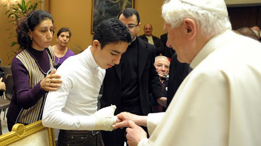 El Papa saluda a uno de los supervivientes del ataque terrorista contra la catedral siro-católica de Bagdad, en octubre de 2010