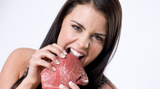 Beautiful Brunette Woman Ripping Raw Red Sirloin Steak Meat With her Teeth &#8211; shutterstock_75859300