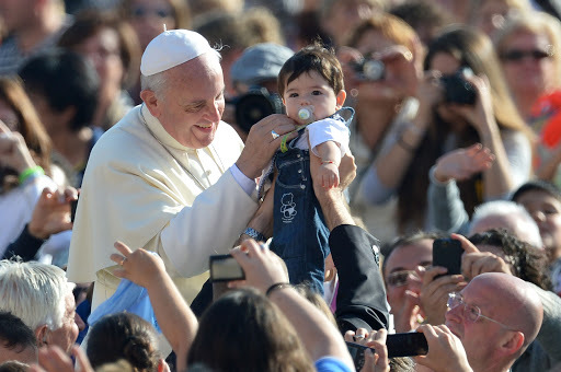 Papa Francisco bendice a un niño en la audiencia general el 16 de octubre.  AFP PHOTO / ALBERTO PIZZOLI