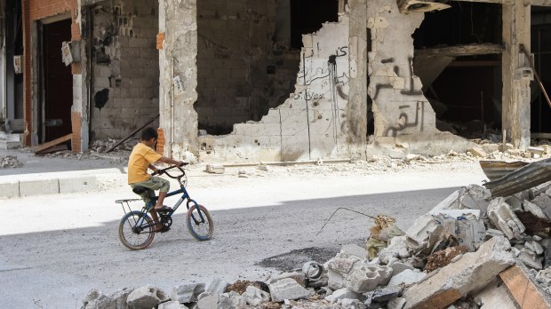web-syria-war-child-bike-ruins-shutterstock_327353597-volodymyr-borodin-ai.jpg
