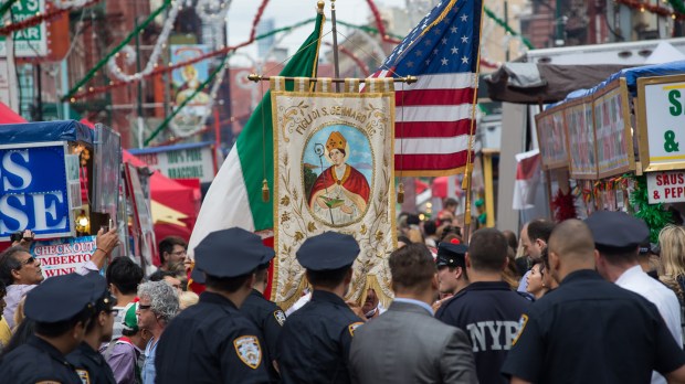 A group of NYPD officers watch as the banner of the festival