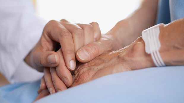 closeup of doctor holding patients hand