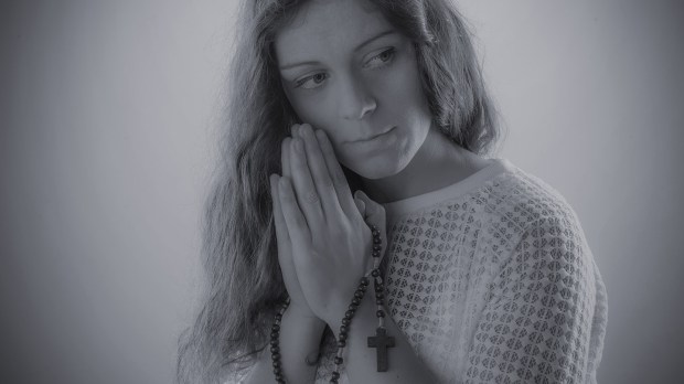 web-woman-pray-distracted-rosary-shutterstock_558368707-uvgreen-ai